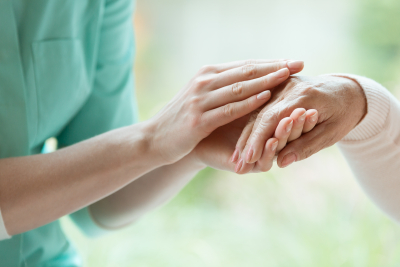 caregiver's hand hold the elder's hand